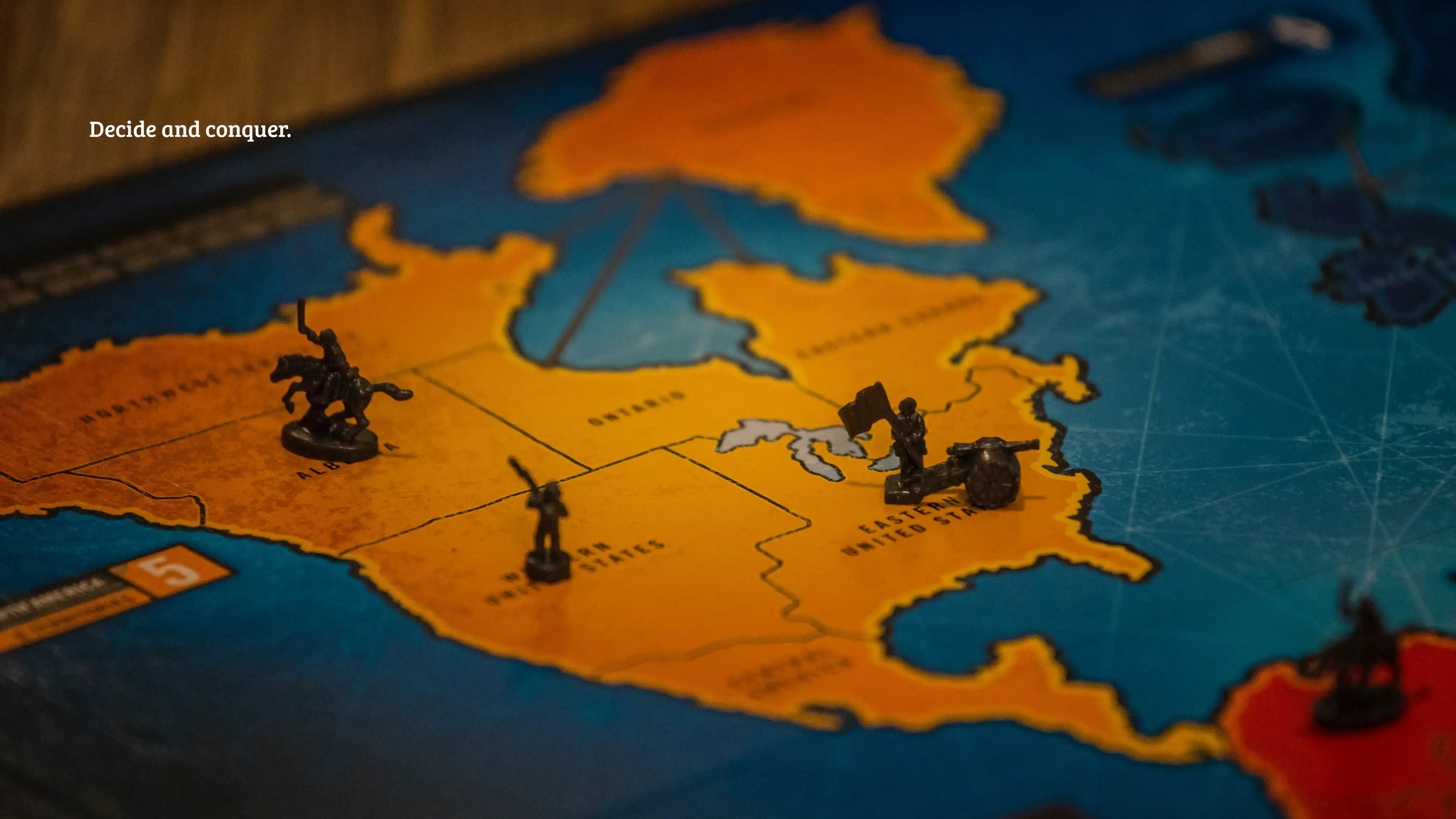 A close-up of a board game on a table. Text: “Decide and conquer.”